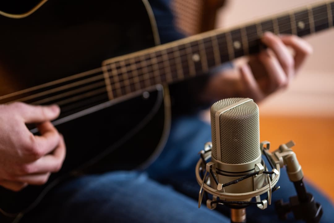 Close-up of acoustic guitar with studio microphone setup