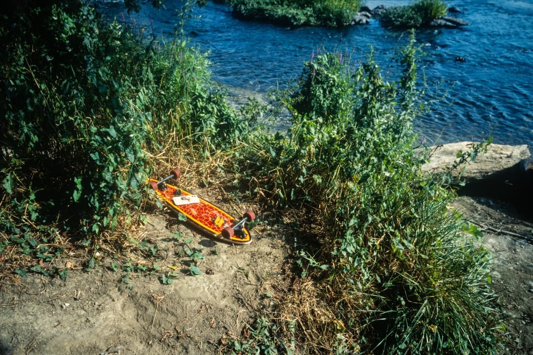 Orange kayak on the bank of a river, outdoor adventure scene