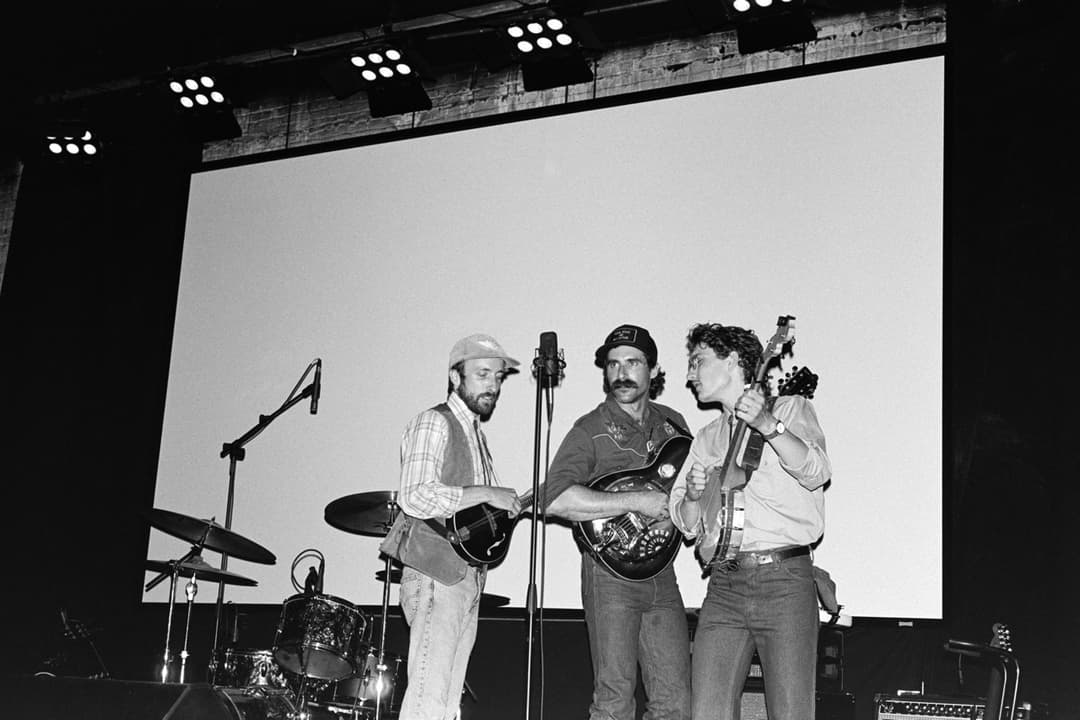 Black and white photo of a band performing on stage, live music concert