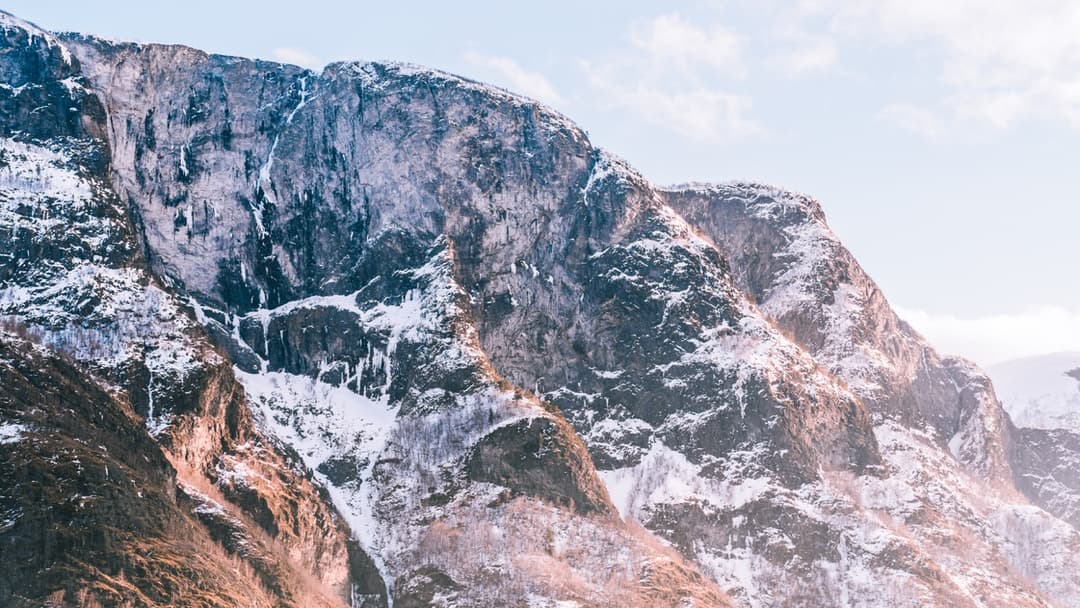 Snow-capped mountain range with rocky cliffs, scenic mountain landscape