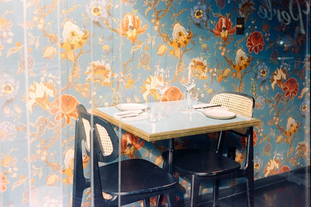 Cozy dining table with floral wallpaper, vintage restaurant interior