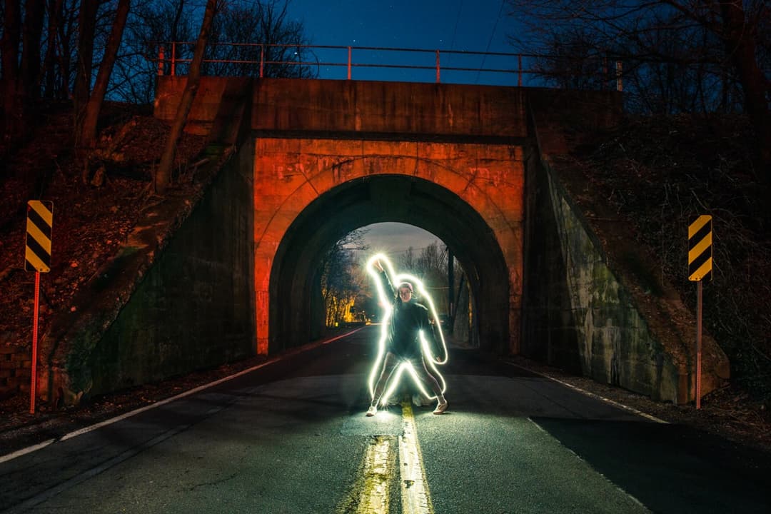 Person with light painting in a tunnel, creative light art photography