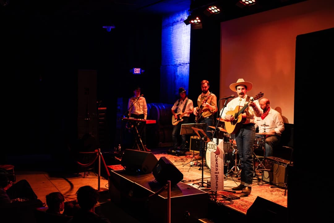 Live band performance: Musicians playing on stage in dimly lit music venue with stage lighting