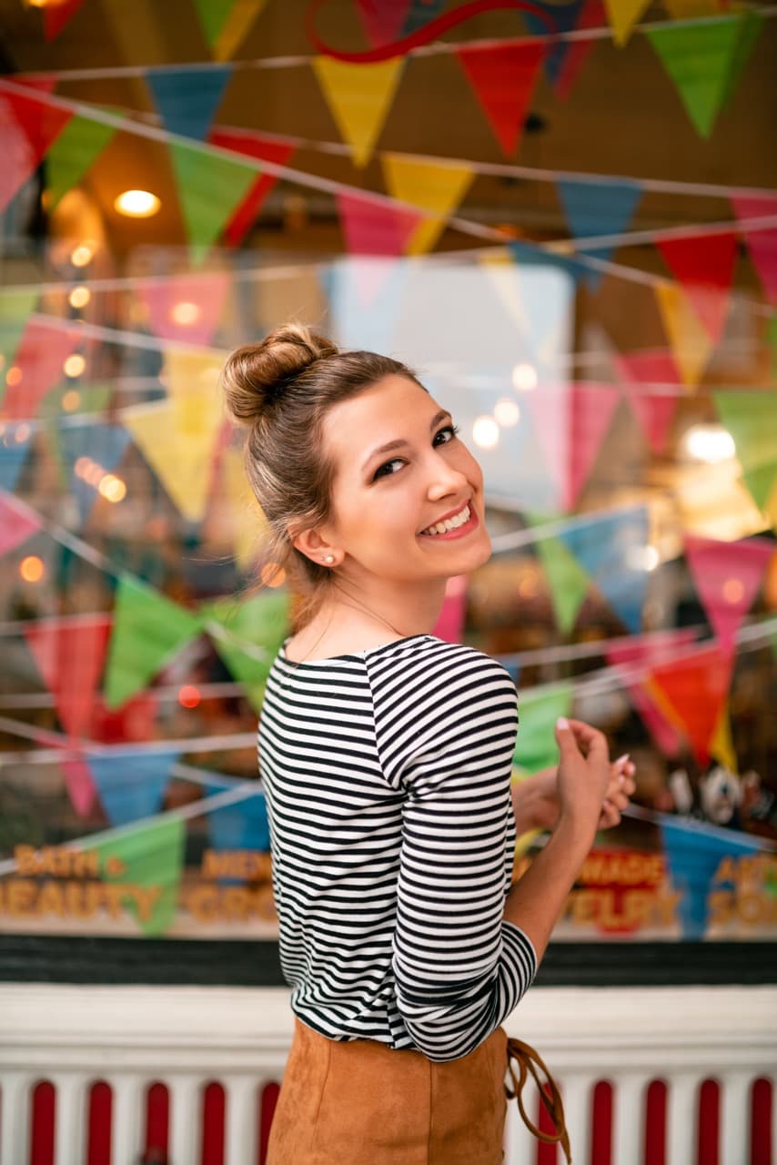 Lifestyle portrait: Woman in striped shirt with colorful background and festive atmosphere