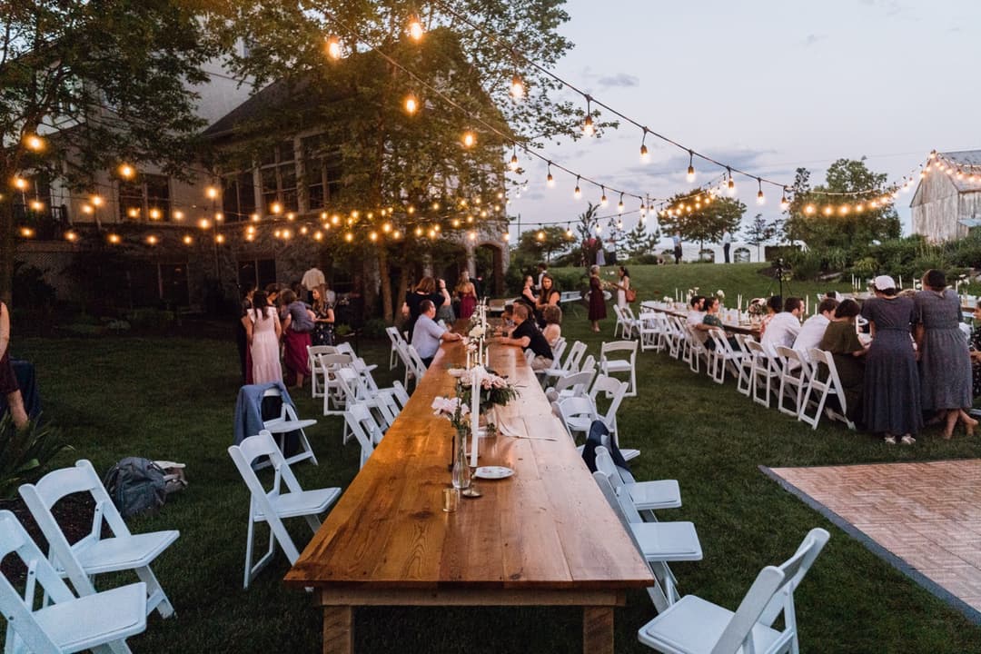 Long wooden table set for an outdoor wedding reception, rustic wedding decor