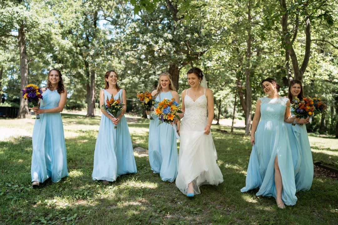 Bride and bridesmaids in light blue dresses, outdoor wedding party photo