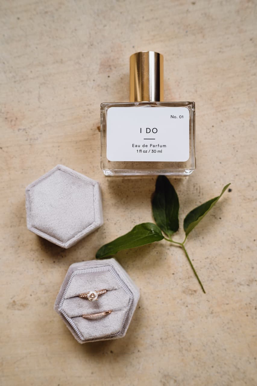 Wedding perfume and rings on a stone surface, wedding detail photography