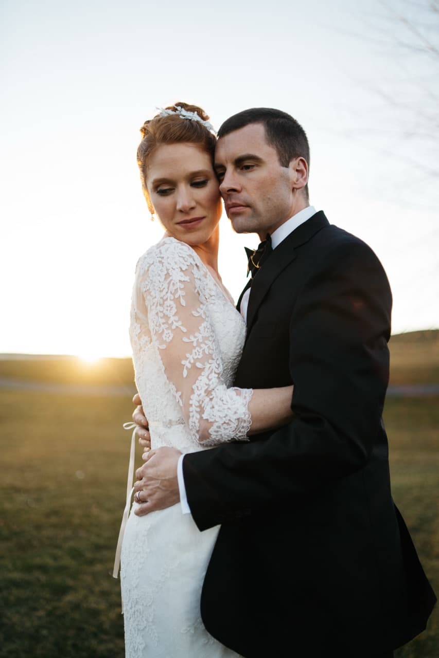 Bride and groom posing at sunset, golden hour wedding photo