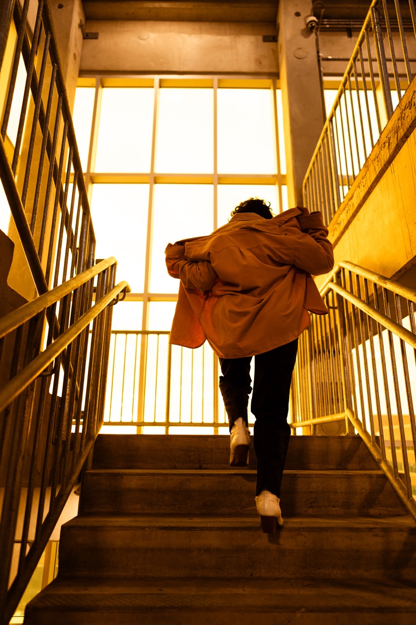 Model ascending stairs in dramatic lighting